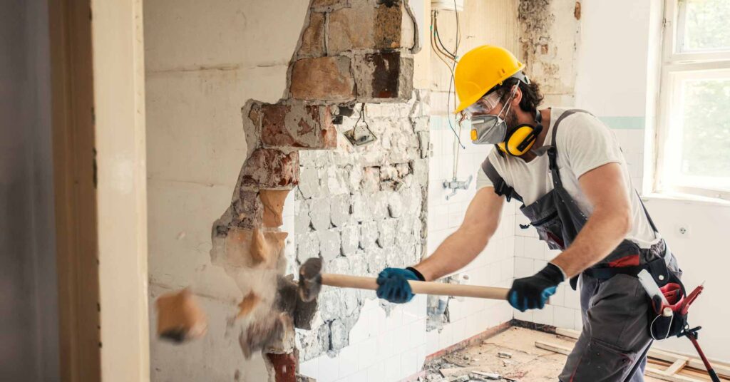 worker using sledgehammer in home renovation