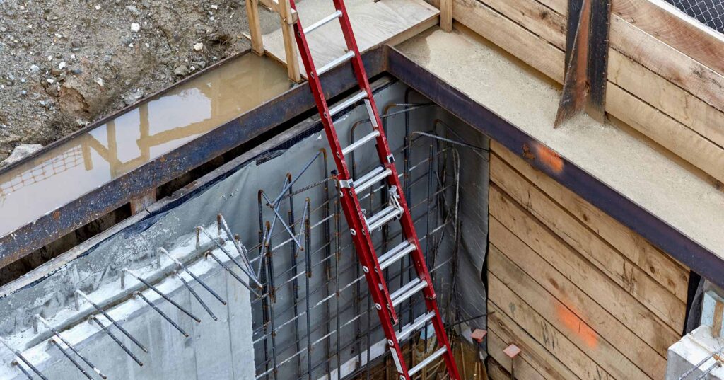 Cement basement foundation walls with rebar and steel reinforcements with ladder