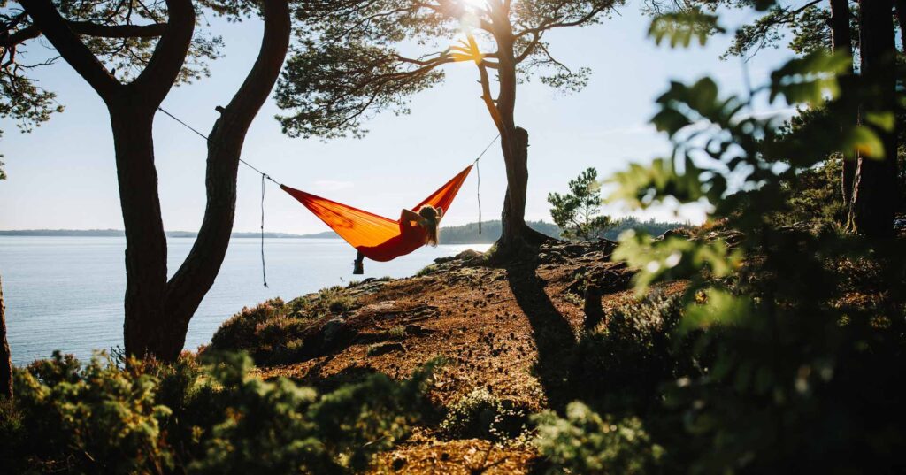 Summer in Norway: adventures in nature outdoor on hammock, by a fjord in Norway