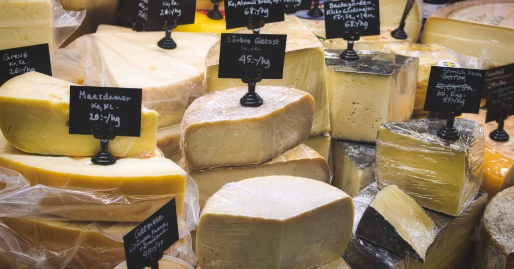 A variety of cheese for sale at the deli counter in a supermarket